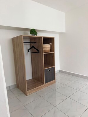 Une armoire en bois avec une tringle et un panier.