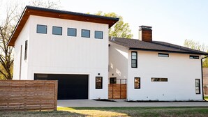 A two-story modern house with a garage, a wooden deck, and a brick chimney. - Mid Mod Studio - Garage, Kitchenette, 0.5 mi UCA (Conway)