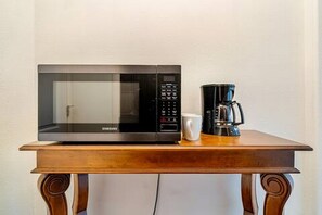 Eine Mikrowelle und eine Kaffeemaschine auf einem Holztisch.