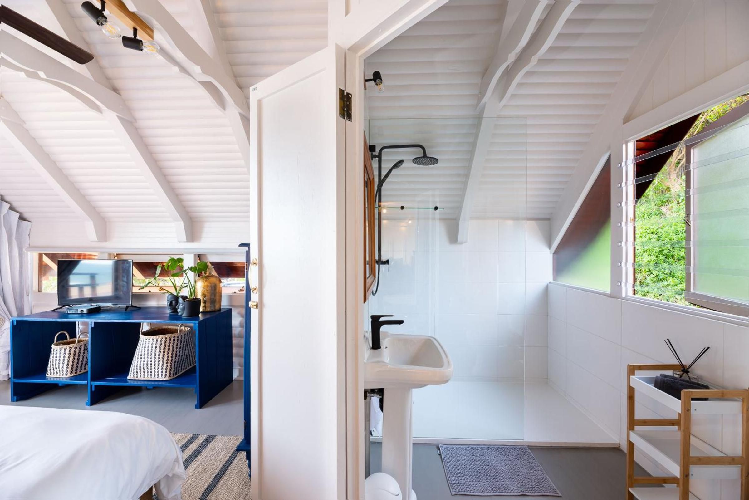 Un baño moderno con ducha, lavabo y vistas a la vegetación.