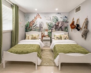 A bedroom with two beds, a mural of animals on the wall, and a window with curtains. - Casa Palma - A South Florida Oasis (Deerfield Beach)