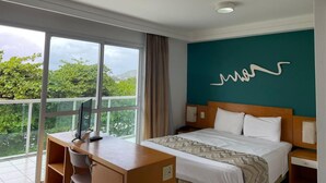 Una habitació d'hotel amb un llit, un escriptori i una finestra gran.