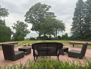 Een terras met rieten meubilair en uitzicht op het water.