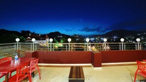 Una terrazza con vista su un paesaggio montuoso di notte.