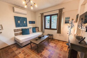 Una habitación con cama, una mesa y una ventana con cortinas.
