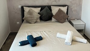 A hotel room with a bed, pillows, a nightstand, and towels. - Elegant and cozy; apparently recently renovated (Béziers)