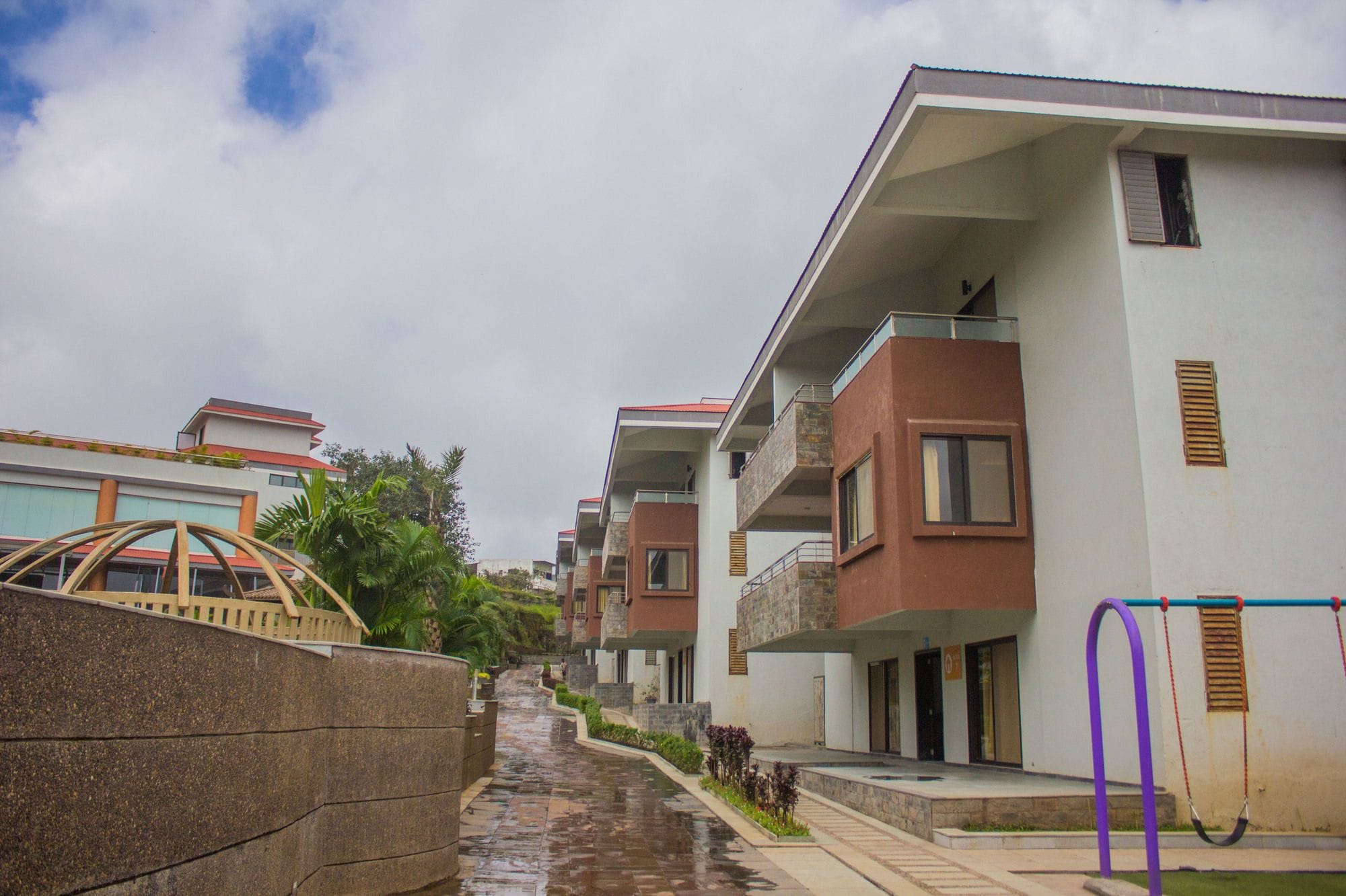 Un quartier résidentiel avec des immeubles d’appartements modernes, une promenade dallée et un mur de soutènement en pierre.