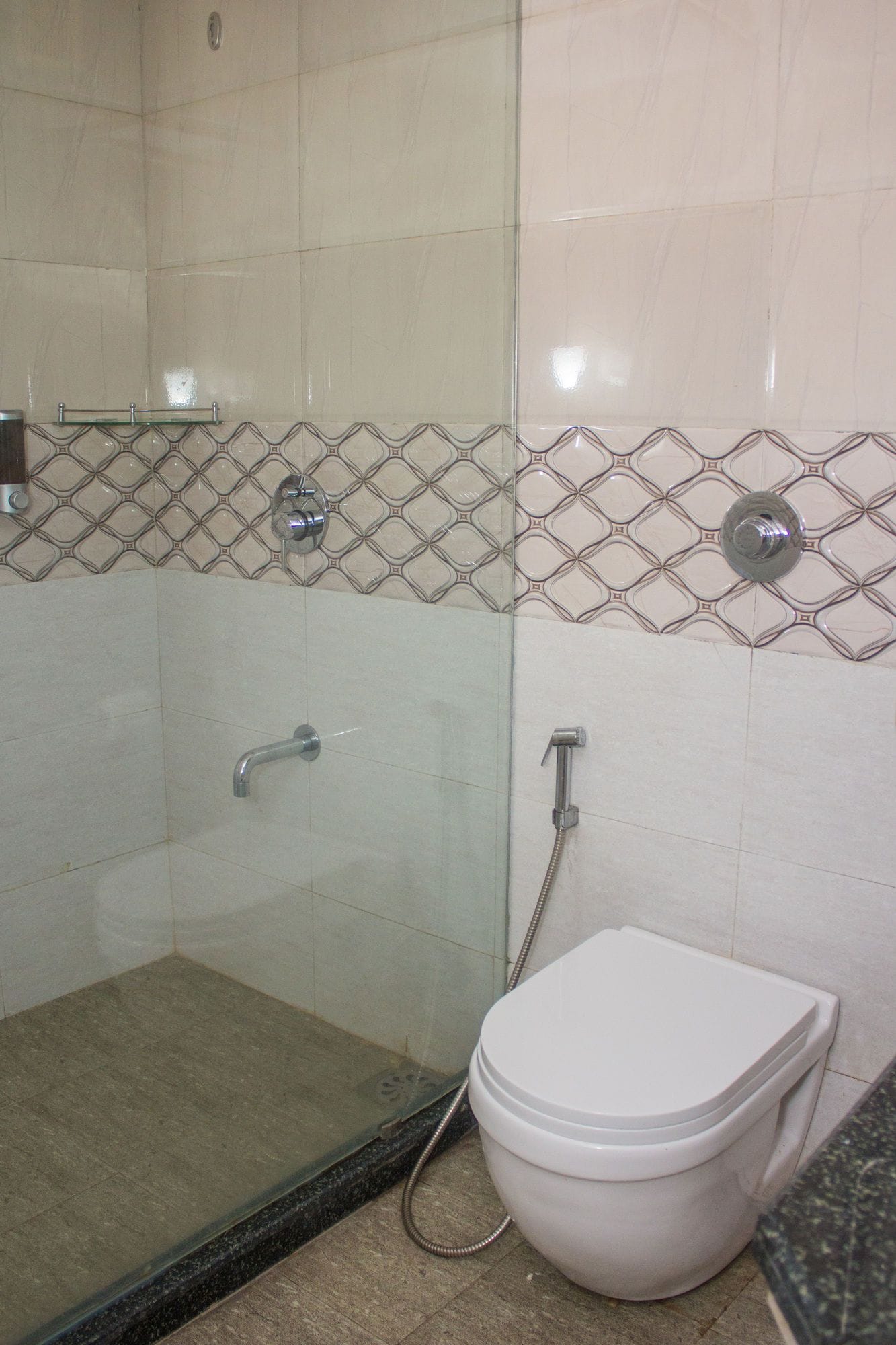 A bathroom with a glass-enclosed shower, a toilet, and a sink.