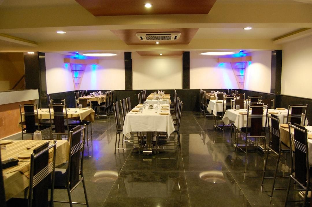 A banquet hall with multiple round tables, chairs, and a central aisle.