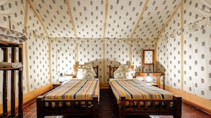 Una habitación con dos camas de madera, un armario de madera y un espejo en la pared.
