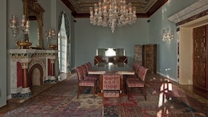 Une salle à manger élégante, agrémentée d’un lustre, d’une cheminée décorative et de meubles de style traditionnel.