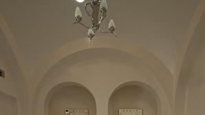 Une salle de bain dotée d’une grande baignoire sur pieds, de deux vasques et d’un lustre.