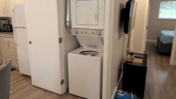 A compact kitchen with a built-in washer and dryer, a microwave, and a small dining area.