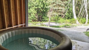 A hot tub with a view of a forested area. - Blacktail Cabin: Hot Tub, Playground, BBQ, Trails (Halfmoon Bay)