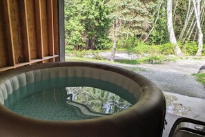 A hot tub with a view of a forested area. - Blacktail Cabin: Hot Tub, Playground, BBQ, Trails (Halfmoon Bay)
