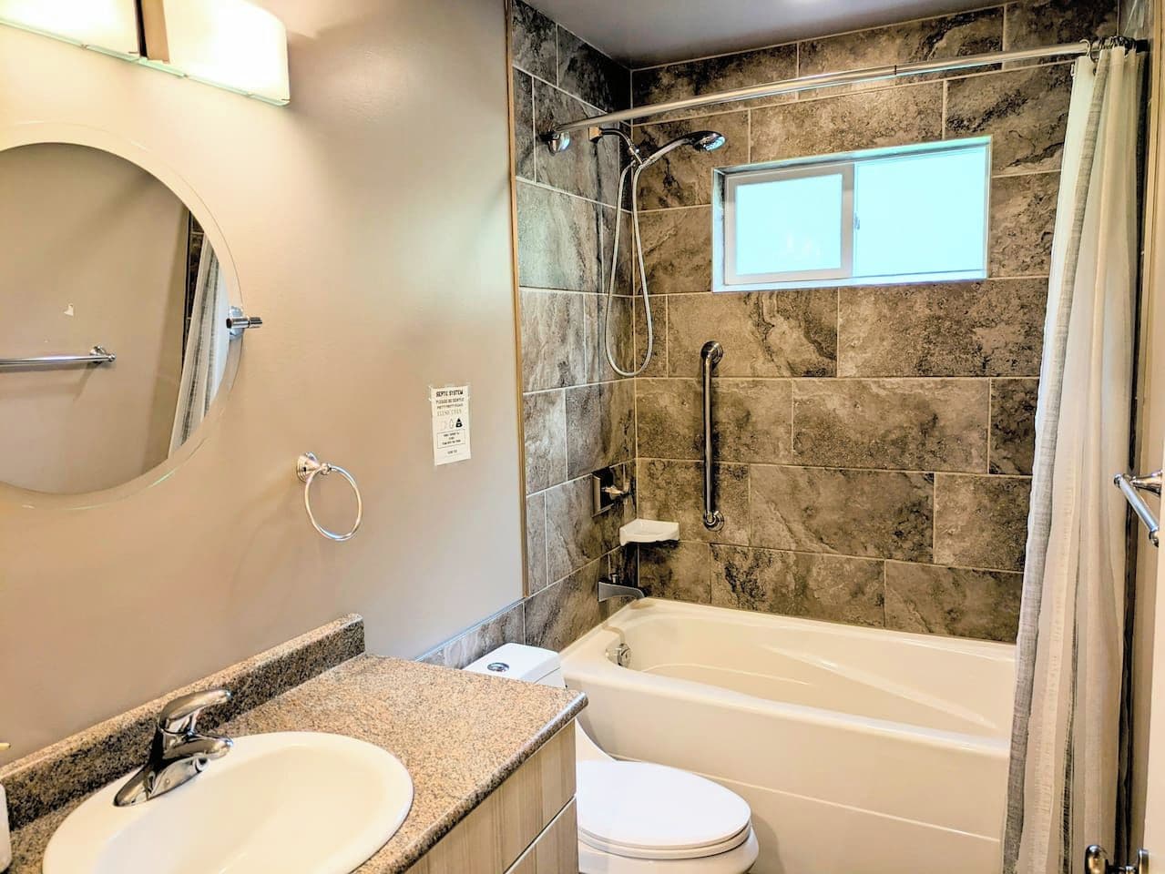 Une salle de bain avec une baignoire, une douche, un lavabo et un miroir.