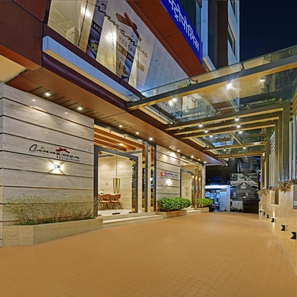 A hotel entrance with a glass canopy, signage for 'Cinnamon Restaurant,' and a 'Comfort Inn Metropolis' sign. - Treebo Metropolis (Mumbai)