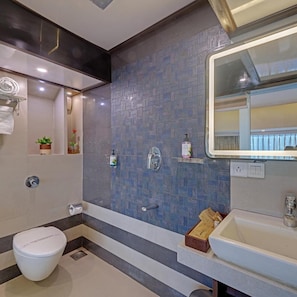 A modern bathroom with a white toilet, a sink, and a mirror. - Treebo Metropolis (Mumbai)