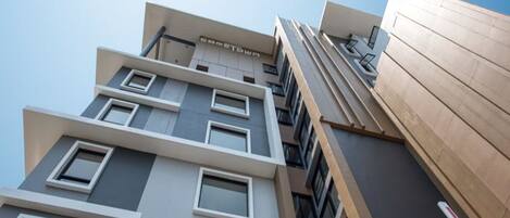 A multi-story building with a modern architectural design, featuring a mix of window styles and a prominent entrance.
