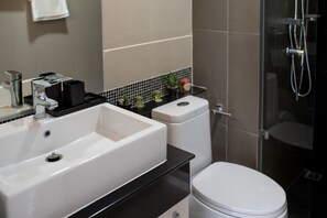 A bathroom with a white sink, black countertop, and a white toilet.
