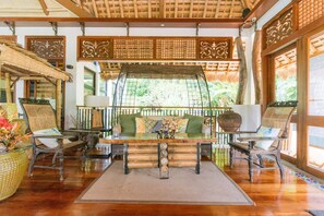 A traditional room with a wooden floor, a central table, and two sofas with cushions. - Damires Hills Tierra Verde (Janiuay)