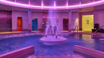 A spa area with a central fountain, multiple doors, and a pool.