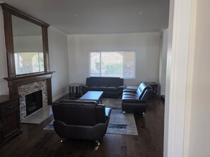 A spacious living room with a fireplace, a large mirror, and a seating area with a sofa and chairs. - Spacious 5-bedroom house in marvelous Rowland Heights with AC (Rowland Heights)