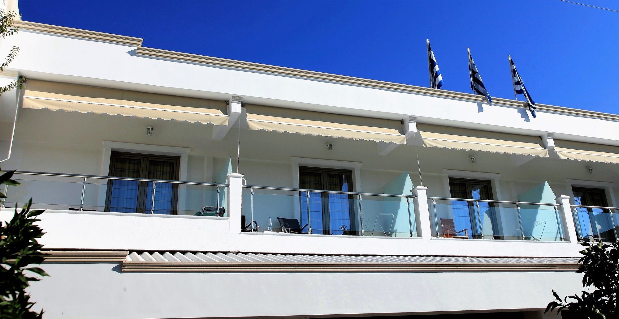A building with a balcony, windows, and flags.