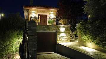 A stone-walled building with a gated entrance, illuminated by exterior lighting.