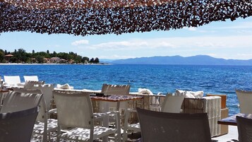 A seaside restaurant with outdoor seating overlooking the sea.