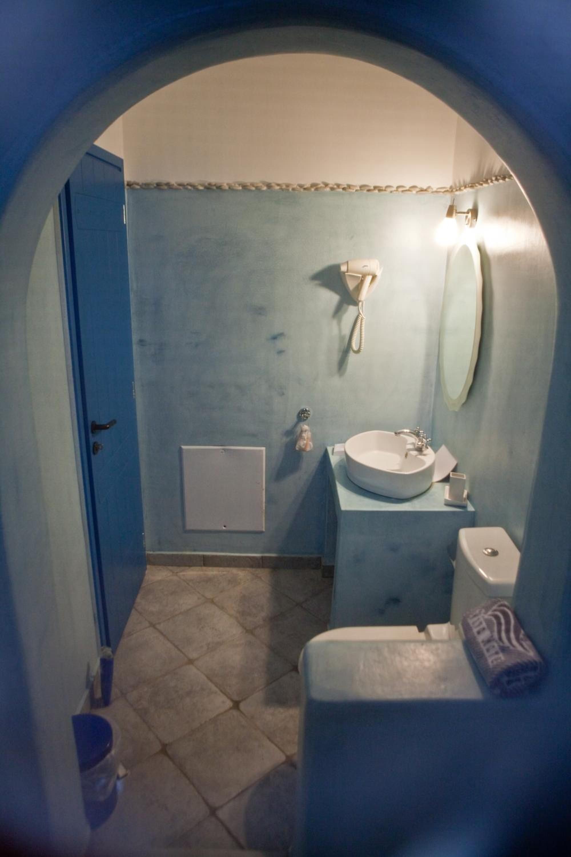Un baño con inodoro, lavamanos y espejo.