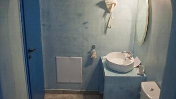 Un baño con inodoro, lavamanos y espejo.