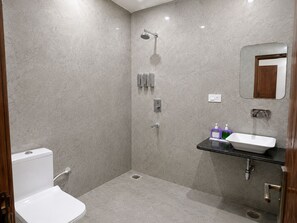 A modern bathroom with a shower, toilet, and sink.