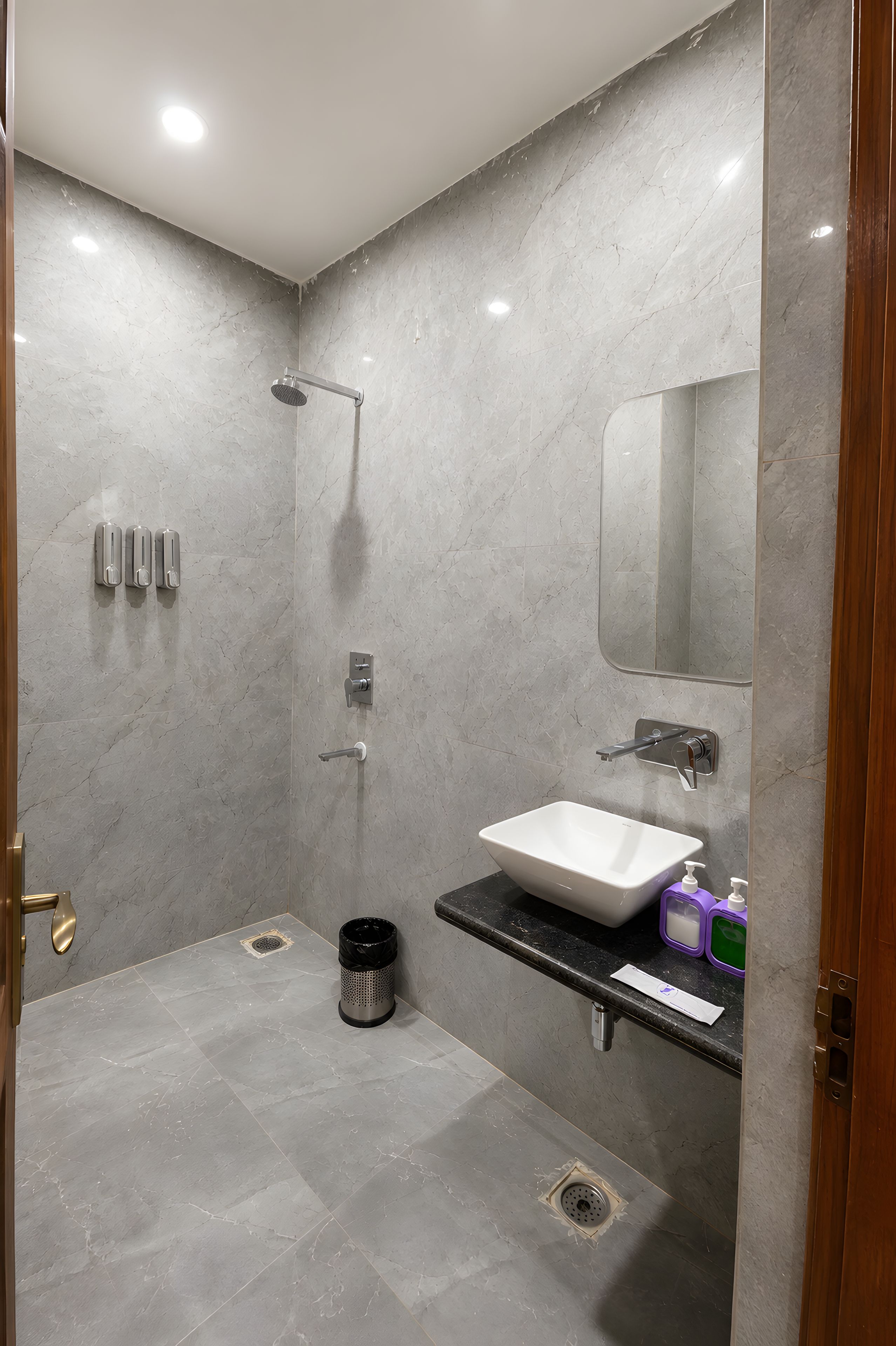 A modern bathroom with a shower, sink, and mirror.