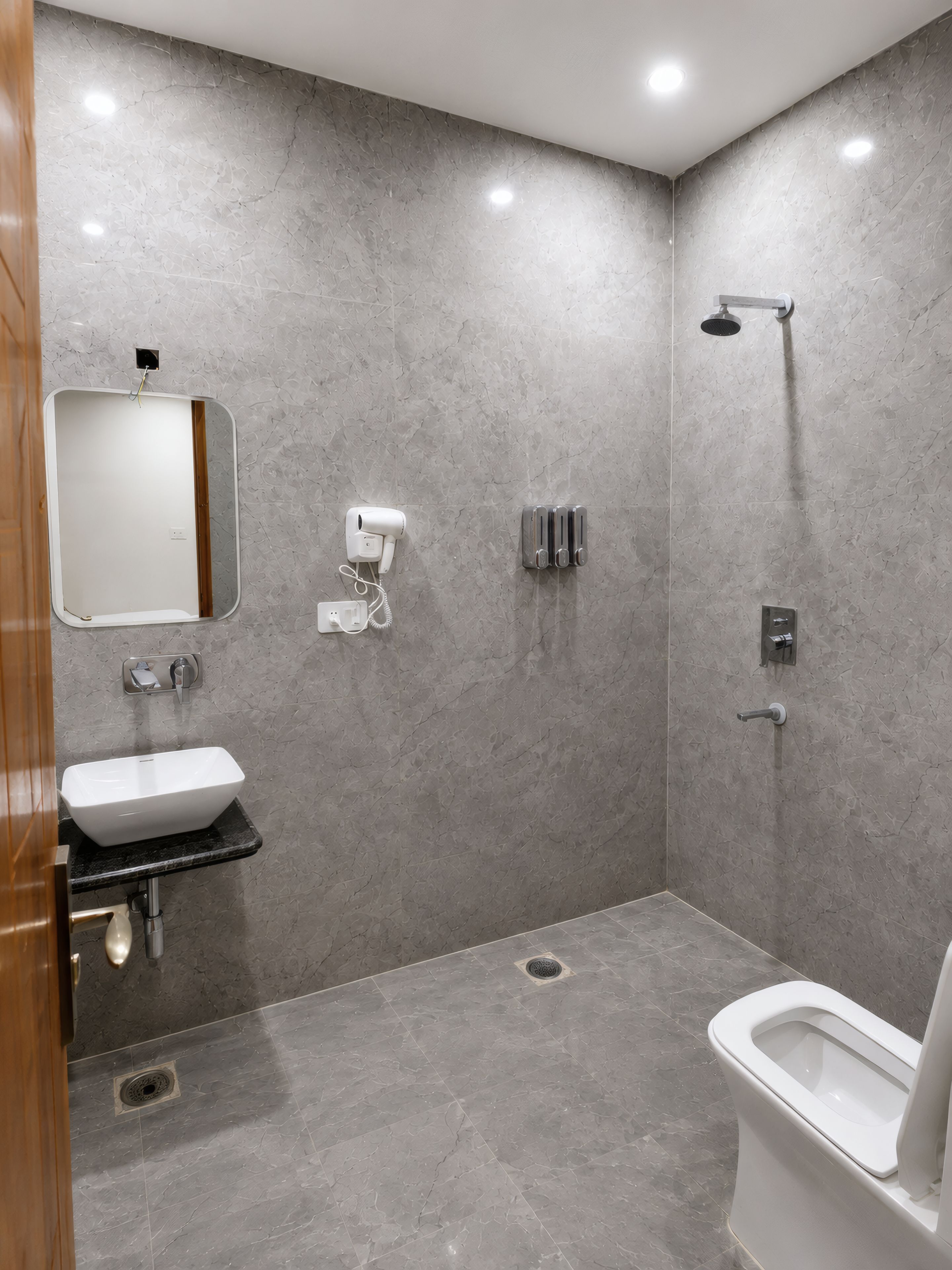 A modern bathroom with a sink, mirror, and toilet.