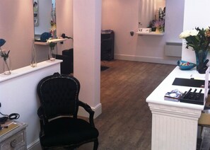 A salon with a black chair, a white counter, and a mirror. - Barnsdale Lodge Hotel And Restaurant (Oakham)