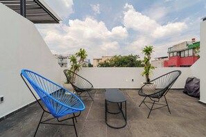 A rooftop terrace with two black wireframe chairs, a small table, and potted plants. - w* | Deluxe 1BR in Escandón w/ Private Terrace (Ciudad de México)