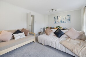 A modern, well-lit bedroom with a sofa, a bed, and a dining area. - Family & Pet Friendly Flat | Free Parking&Wi-fi (Ceredigion)