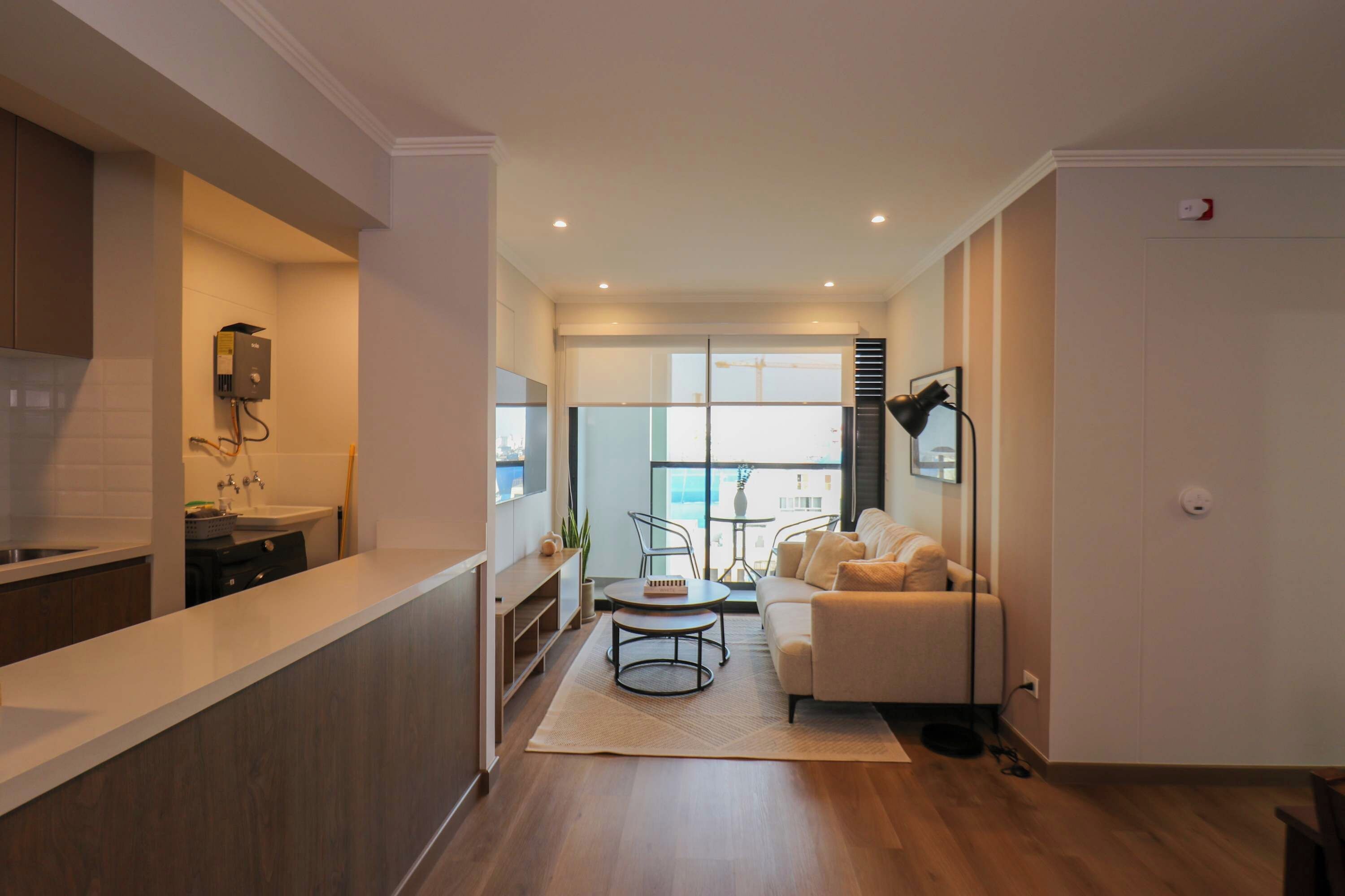A modern kitchen with a built-in oven and a dining area with a round table and chairs.