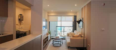 A modern kitchen with a built-in oven and a dining area with a round table and chairs.