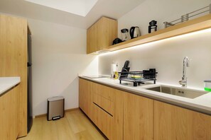 A modern kitchen with wooden cabinets, a stainless steel sink, and a built-in oven. - w | Upscale 2BR with Private Terrace in Roma Norte (Ciudad de México)