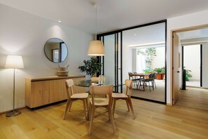 A modern dining area with a glass table, wooden chairs, a round mirror, and a floor lamp. - w* | Luxury 2BR with Private Terrace in Roma Norte (Ciudad de México)