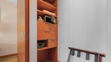 A wooden closet with shelves, drawers, and a hanging rack.