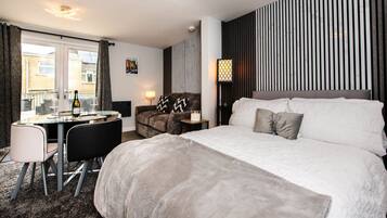 Een hotelkamer met een bed, een bureau, een stoel, een lamp en uitzicht.