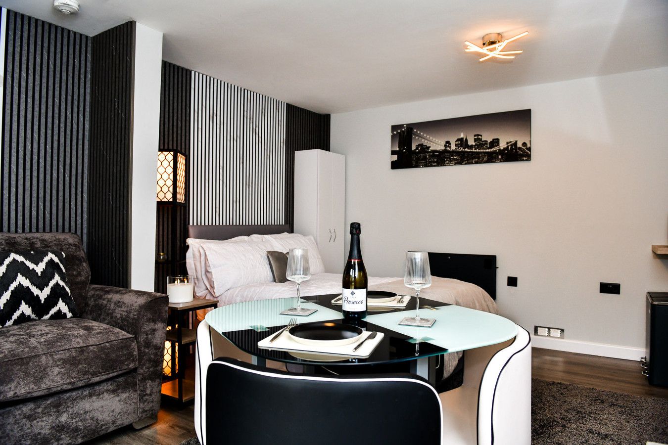 Une chambre d’hôtel moderne équipée d’un lit, d’une table à manger et d’un canapé.