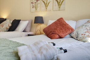 A hotel room with two beds, a bedside lamp, and floral artwork on the wall. - Stylish Canton Retreat with Private Garden – Short Distance to Cardiff Castle & Stadiums! (Cardiff)