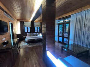 A wooden interior with a bed, a desk, and a TV. - Aamby Valley City, Lonavala (Paud)