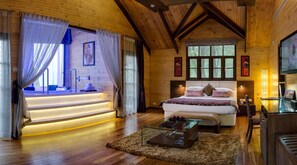 A bedroom with a large bed, a desk, and a view of the outdoors. - Aamby Valley City, Lonavala (Paud)