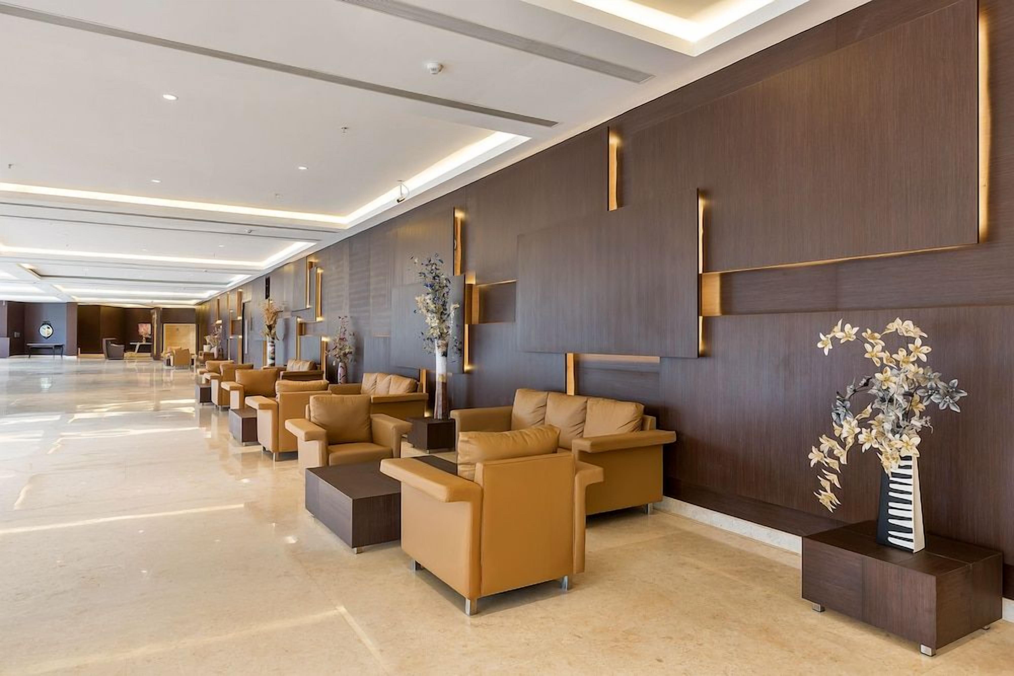 A modern lobby with a row of sofas and a reception desk.