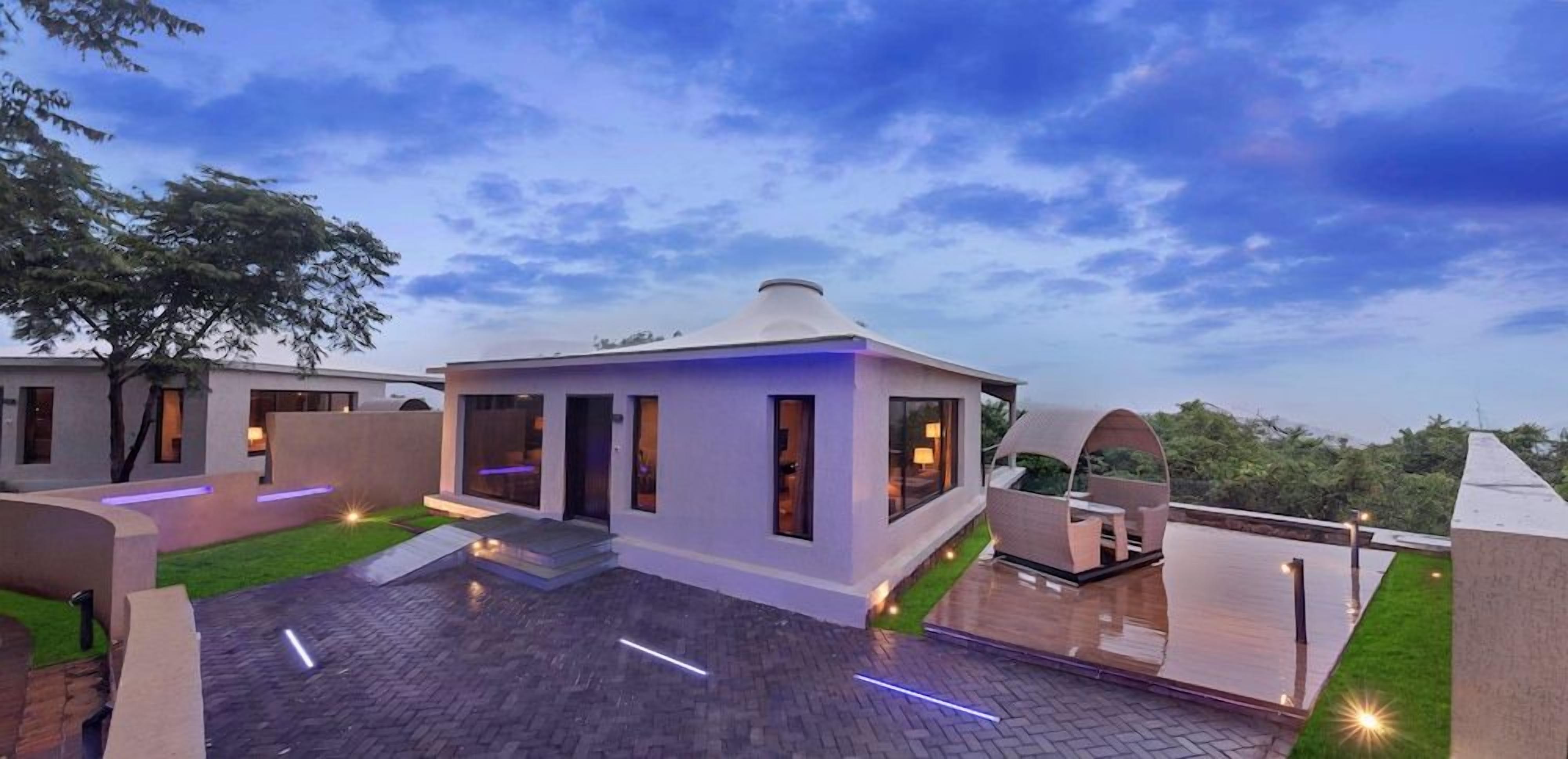 A modern building with a flat roof, a covered outdoor area, and a paved courtyard.